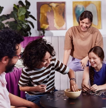 Pessoas em uma sala de estar montando um quebra-cabeça.