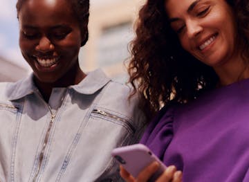 Young man holding cellphone with both hands looking closely at the screen