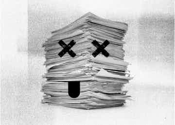 Pilha de papel com dois X nos olhos e uma língua caída em preto e branco e aparência de impressão antiga em fax.
