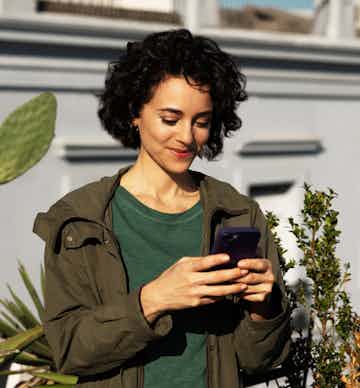 Mulher sorrindo olhando para seu celular