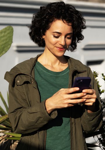 Mulher sorrindo segurando o cartão roxinho do Nubank