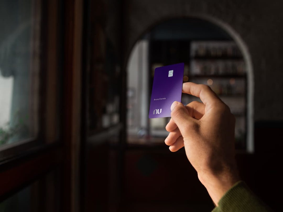 imagem de uma mão segurando o cartão ultravioleta do nubank