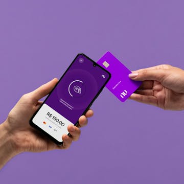 A hand holding a cellphone while another one approximate a card on it