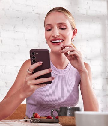 mulher comendo cereja enquanto olha o aplicativo do nubank em seu celular