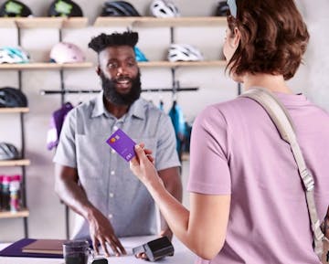 Mulher com cartão Nubank em loja de itens esportivos