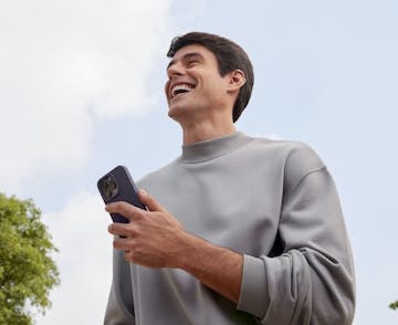 Man holding cell phone in an outdoor environment