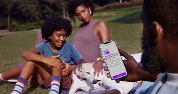 Man with his family in the park using his cell phone