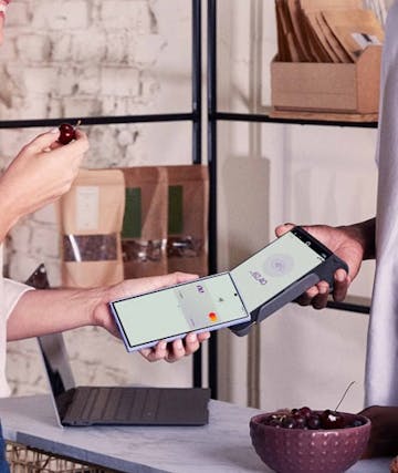 Woman paying bill on machine by approaching her cell phone