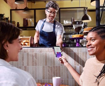 Women paying by contactless means with Nubank Card at the coffee shop