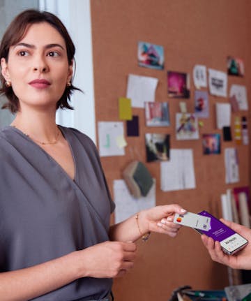 Mulher utiliza cartão Nubank business para pagamento por aproximação